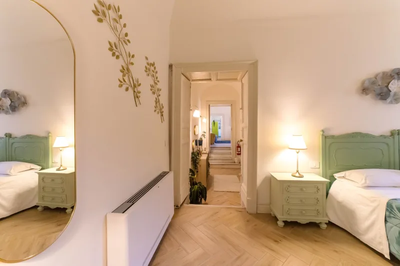 Twin bedroom with green headboards and gold wall decor
