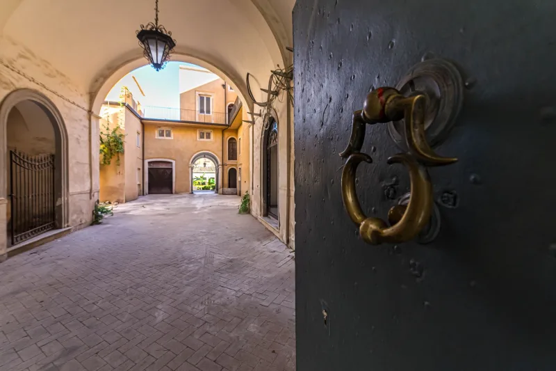 The arched courtyard entrance of the Sikelia Palace, with its door knocker