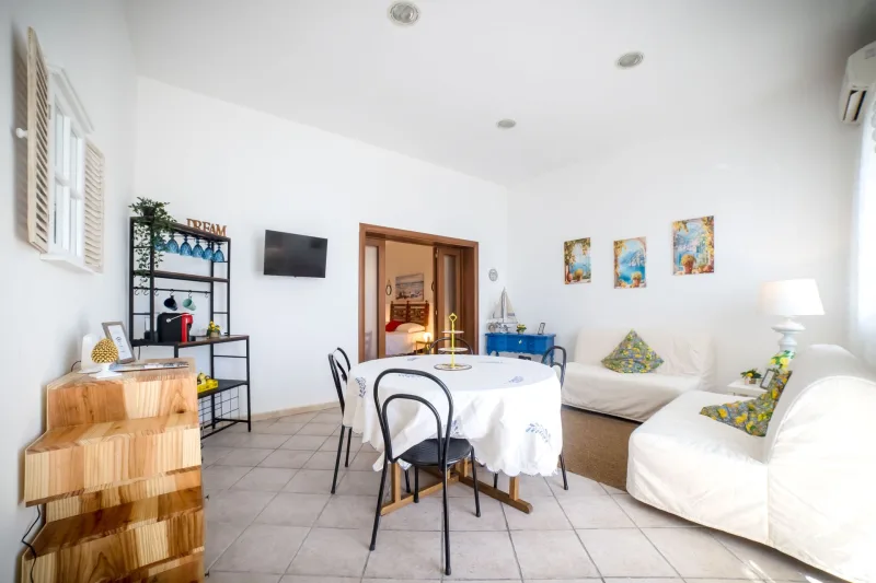 Bright living room with dining table and white sofas