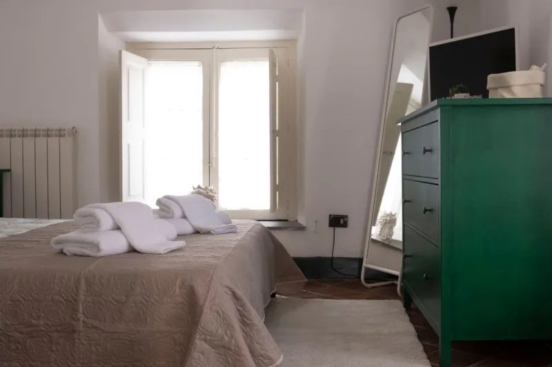 Bedroom with green chest of drawers and window