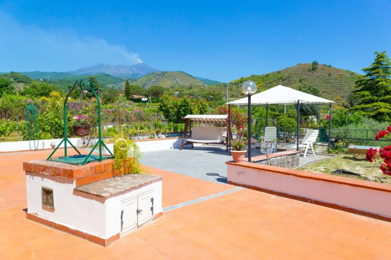 Terrace with gazebo and garden, Mount Etna smoking behind