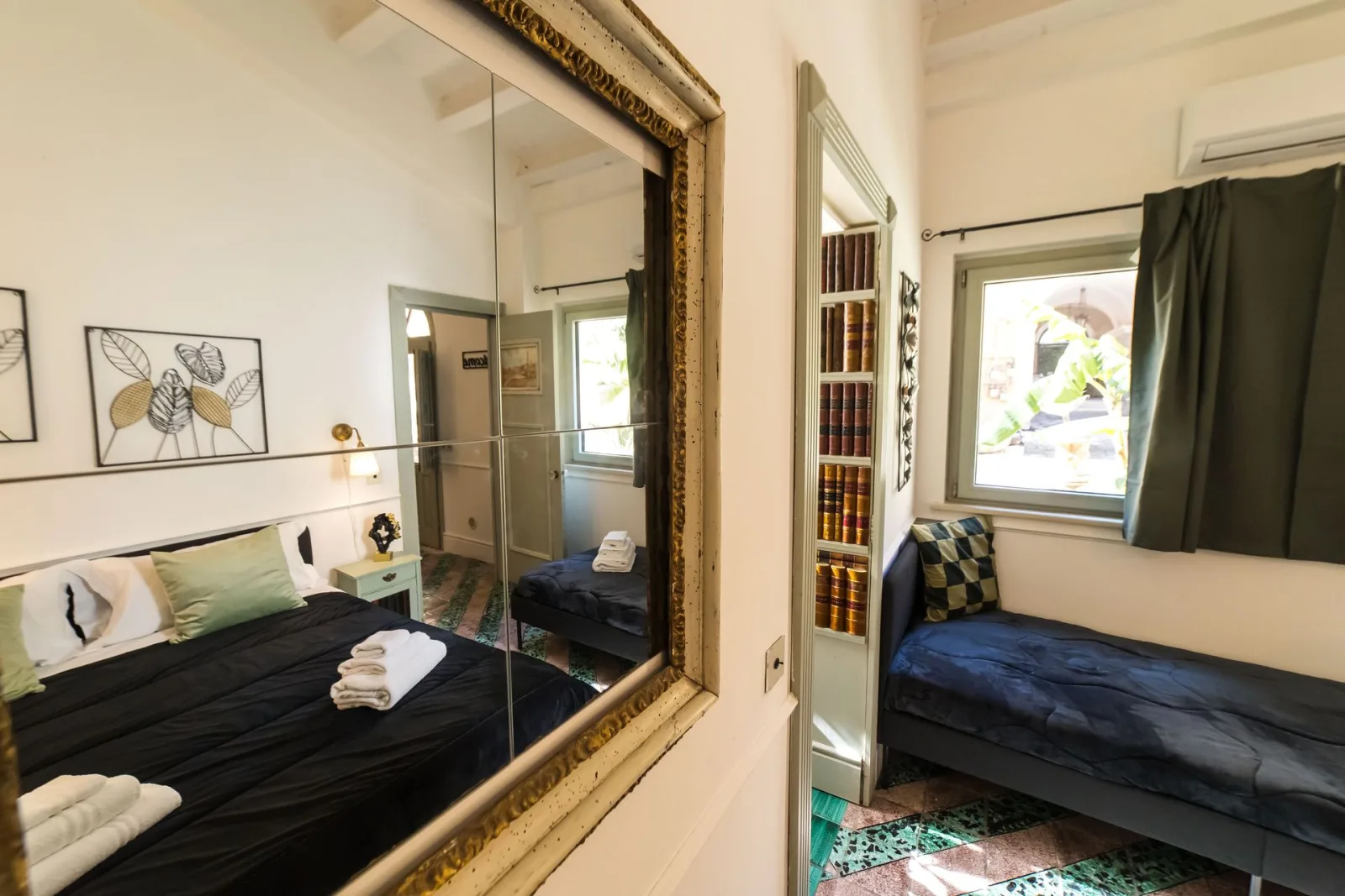Bedroom with large gilt mirror, sofa and window