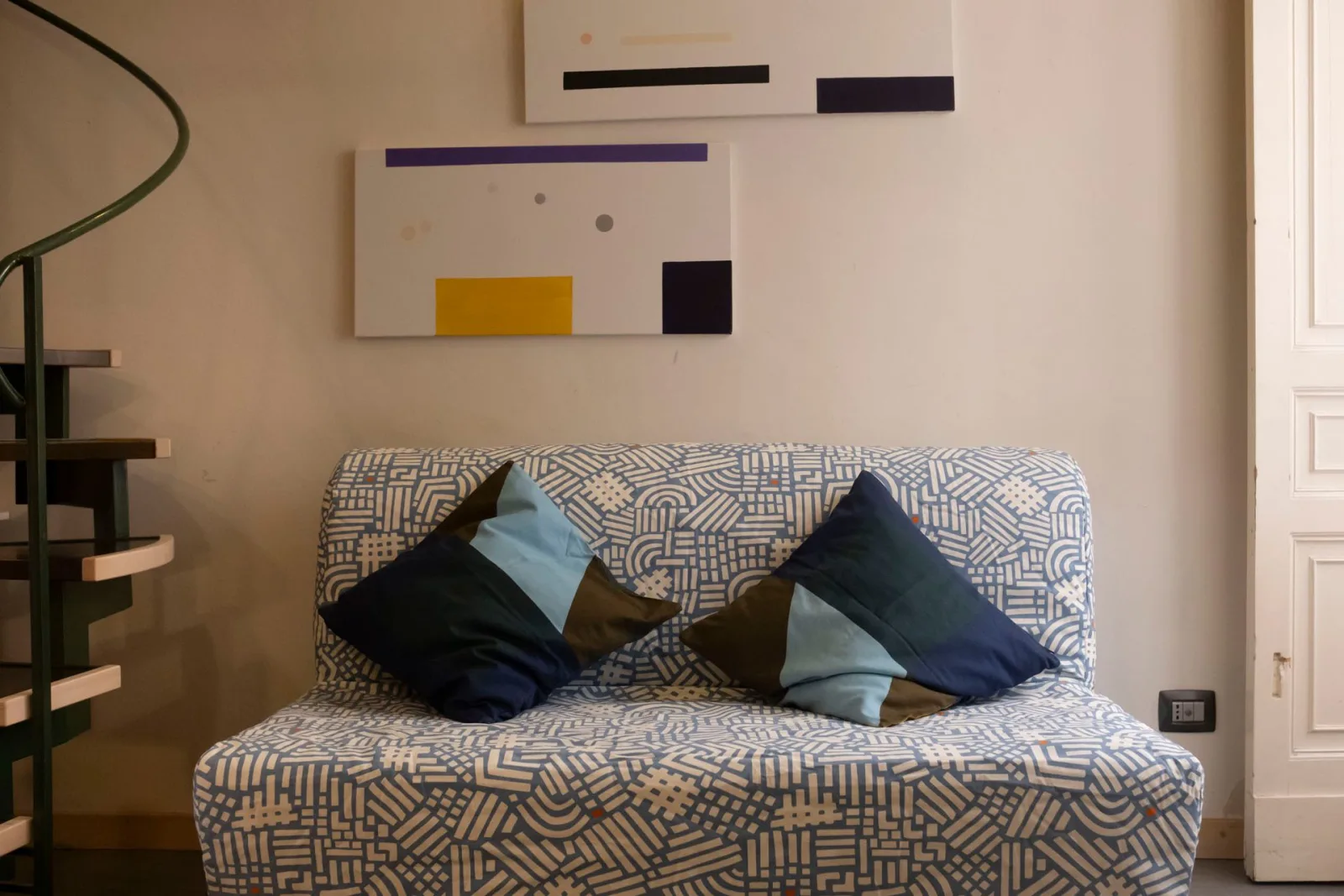 Living area with patterned sofa bed and modern art