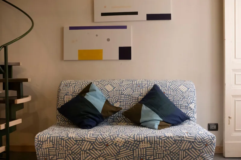 Living area with patterned sofa bed and modern art