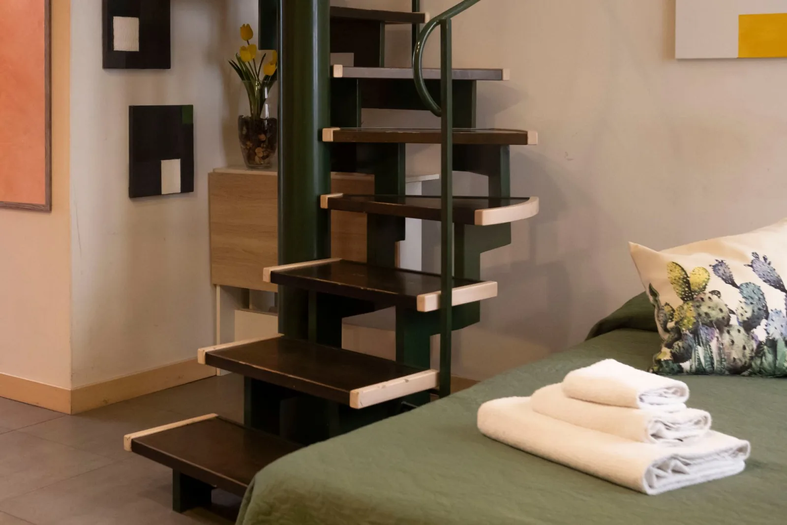 Bed beside the open spiral staircase