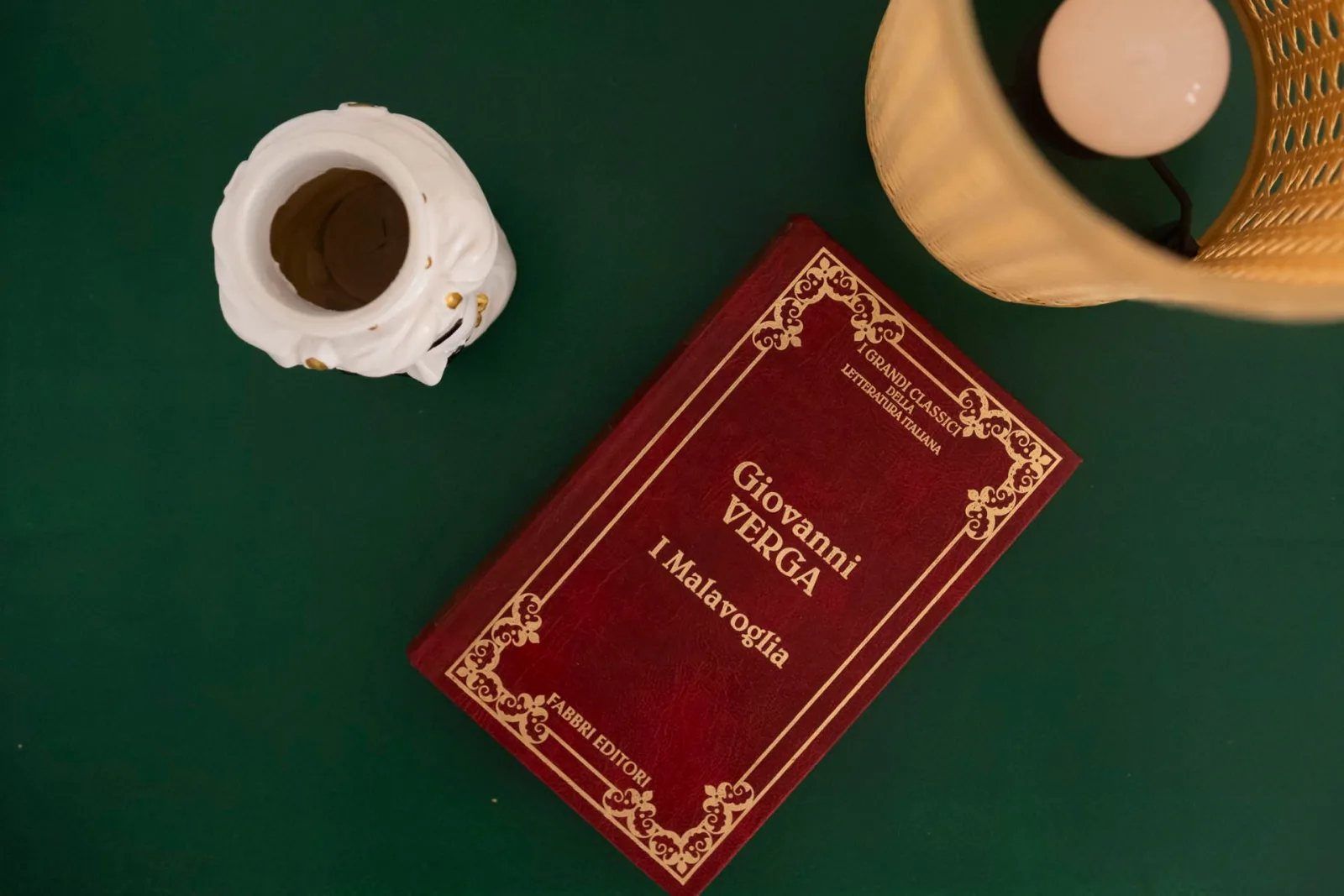 Espresso and a Verga novel on a green table