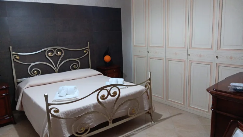 Bedroom with wrought-iron bed and built-in wardrobe